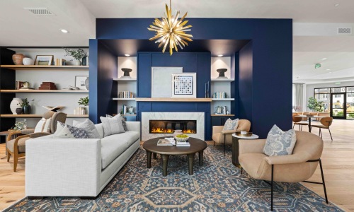 a clubroom with a couch, tables and chairs